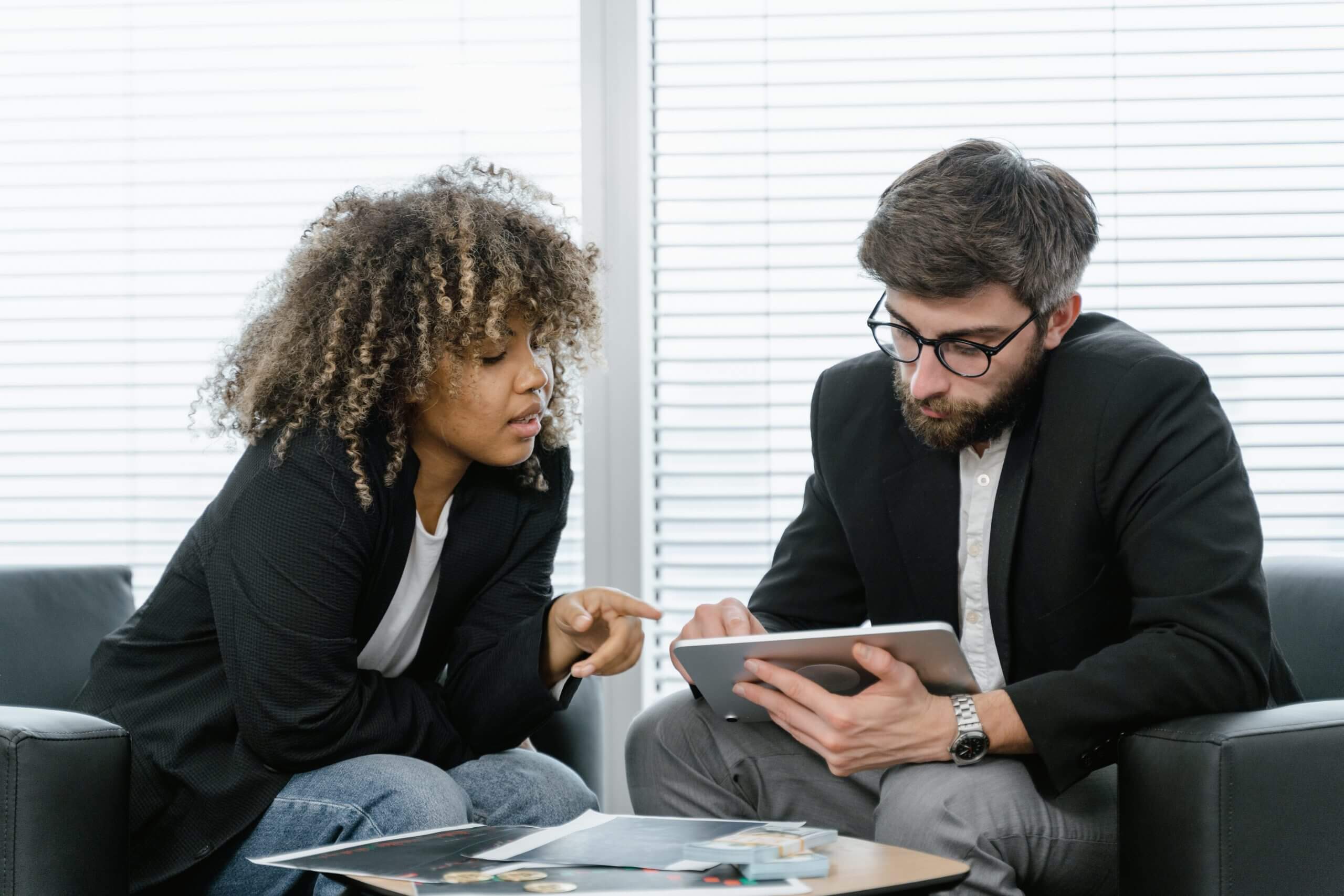 businessman and woman meeting and looking at ipad